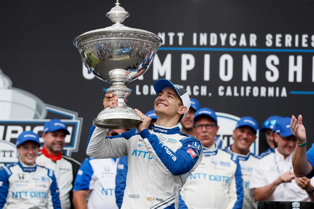 Alex Palou, center, celebrates after winning the 2021 IndyCar season championship.