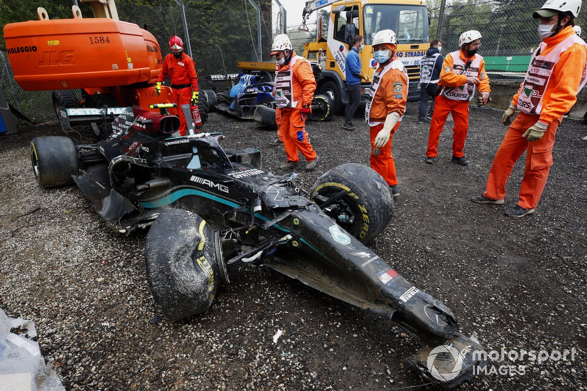 Marshals clear Valtteri Bottas' damaged Mercedes W12 car from the gravel trap