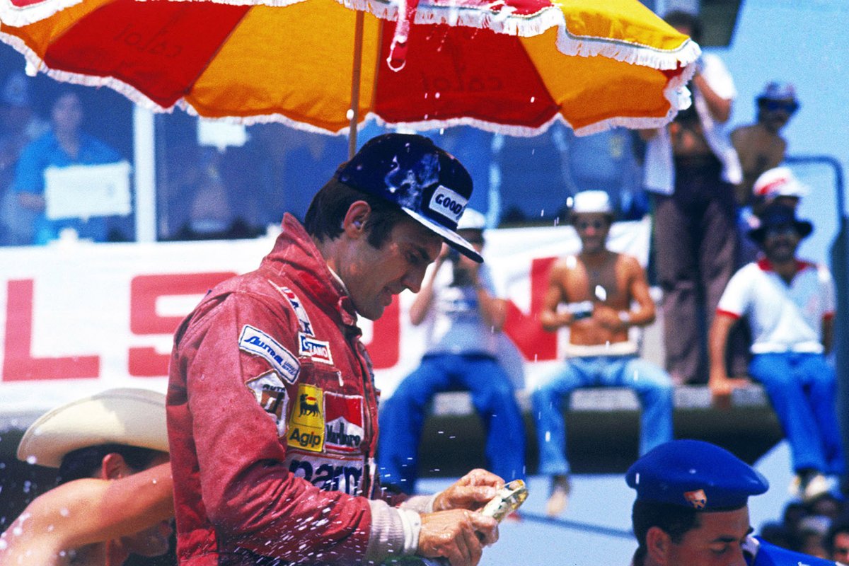 Carlos Reutemann, Ferrari celebrates its victory on the podium while trying to open its bottle of champagne