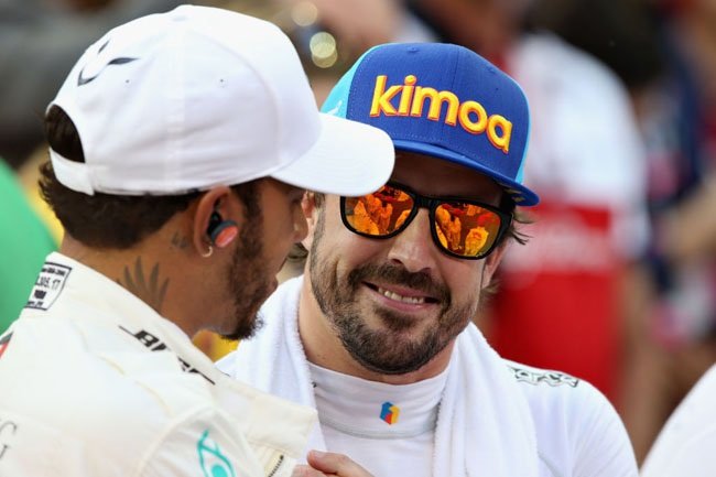 Lewis Hamilton of Great Britain and Mercedes GP and Fernando Alonso of Spain and McLaren F1 talk on the grid before the Abu Dhabi Formula One Grand Prix at Yas Marina Circuit on November 25, 2018 in Abu Dhabi, United Arab Emirates.