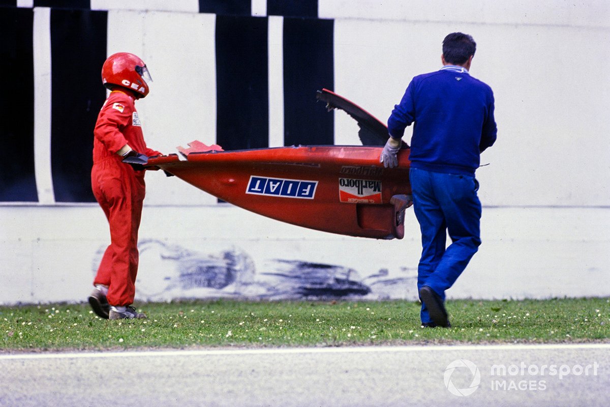 Marshals carry away the rear body of Gerhard Berger's Ferrari 640 after an accident