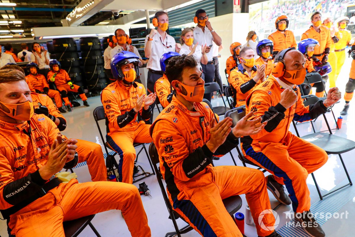 The McLaren pit crew cheer the efforts of their drivers at the start
