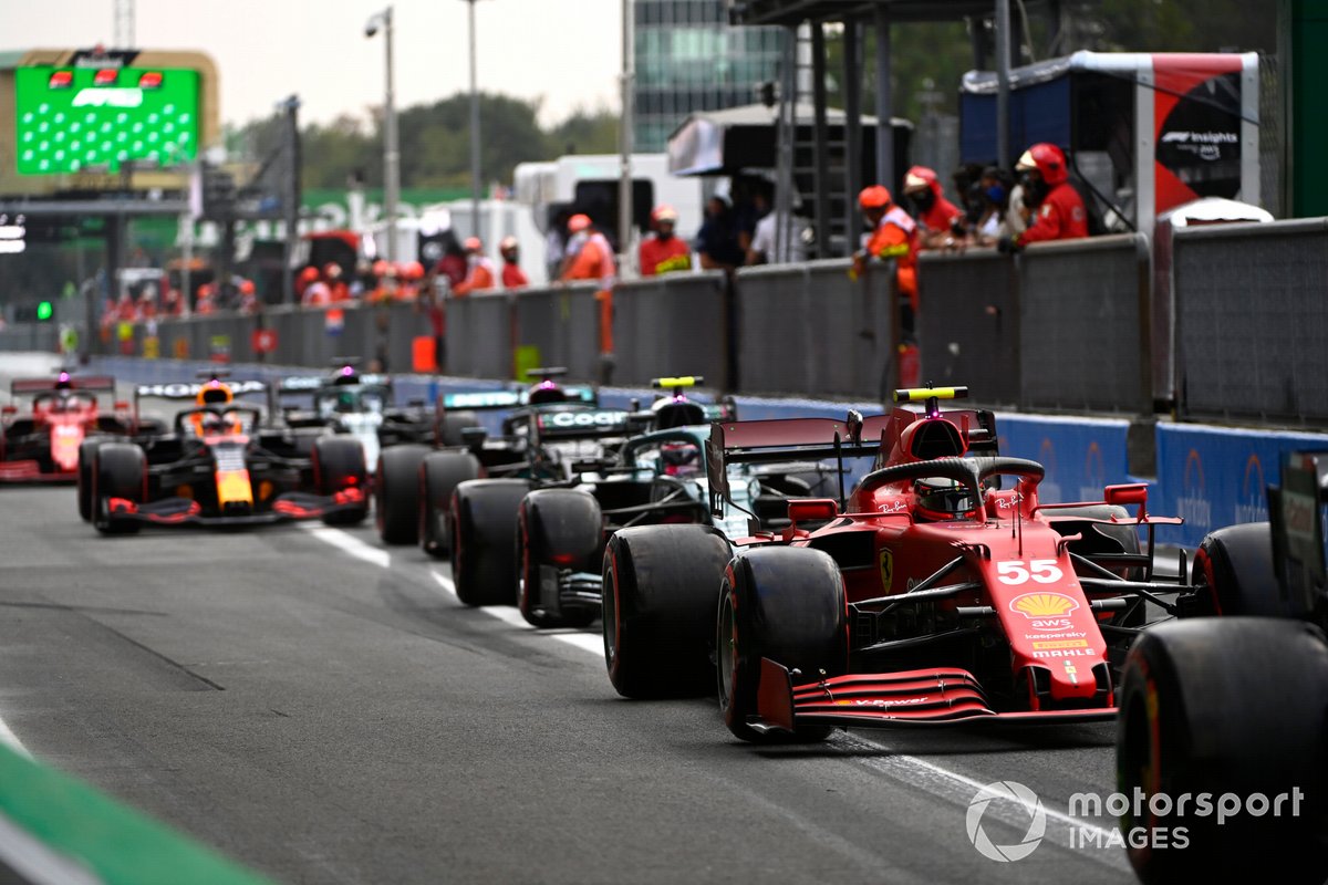 Carlos Sainz Jr., Ferrari SF21, Sebastian Vettel, Aston Martin AMR21, and others in the pit lane