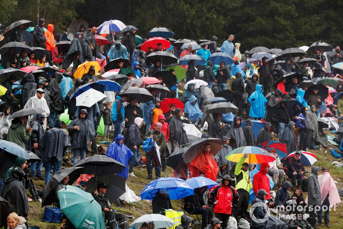 Fans under umbrellas during a red flag period
