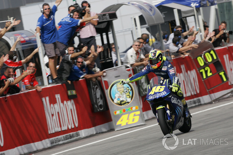 Rossi takes the checkered flag in Sepang 2004 to applause from his team