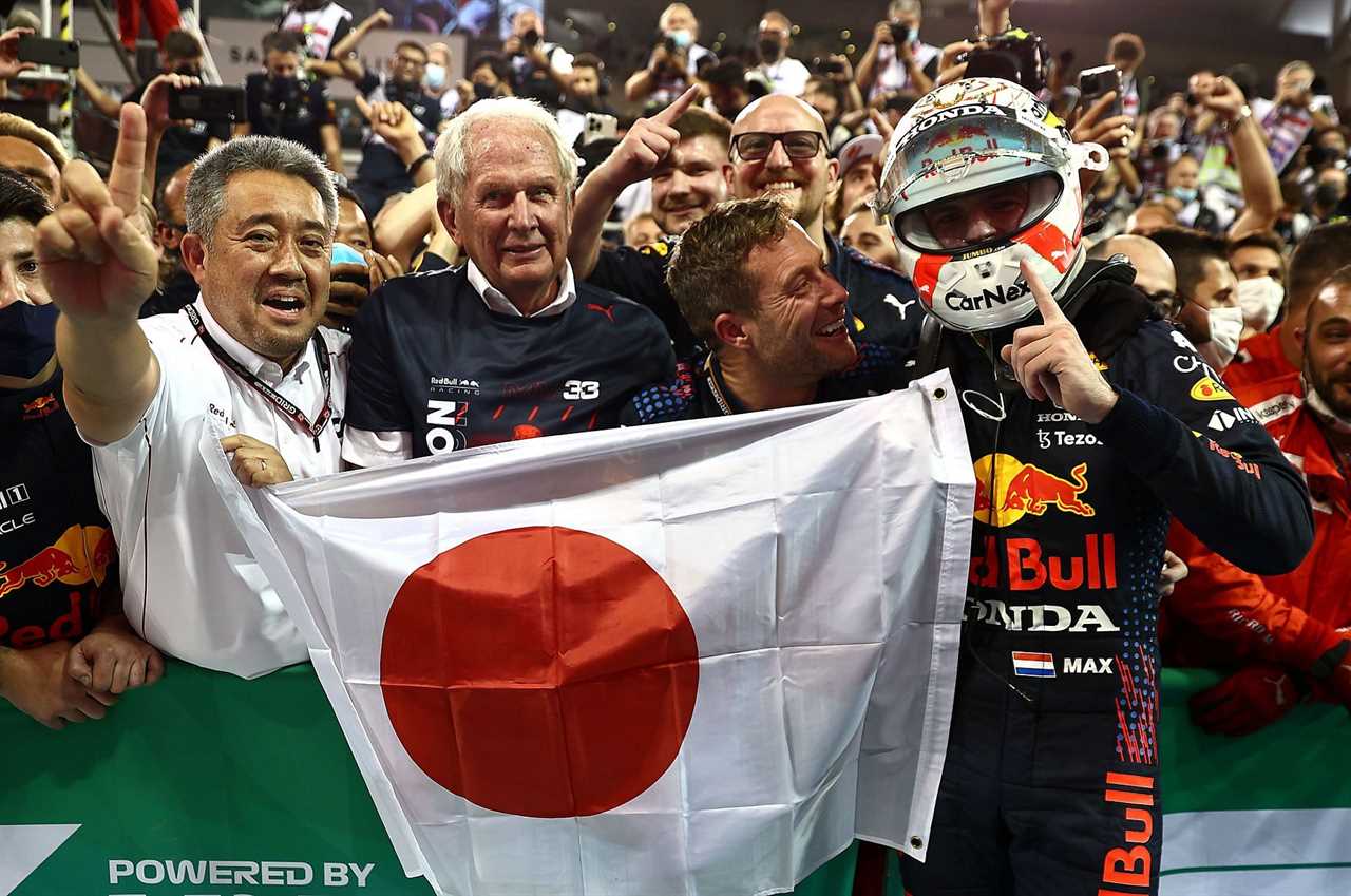 Max Verstappen (right) celebrates with Dr. Helmut Marko (left of center) and Masashi Yamamoto (left) after winning the 2021 Drivers' Championship