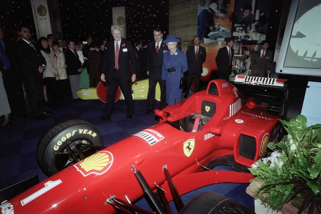 Queen Elizabeth II walks past German Formula 1 driver Michael Schumacher's Ferrari.