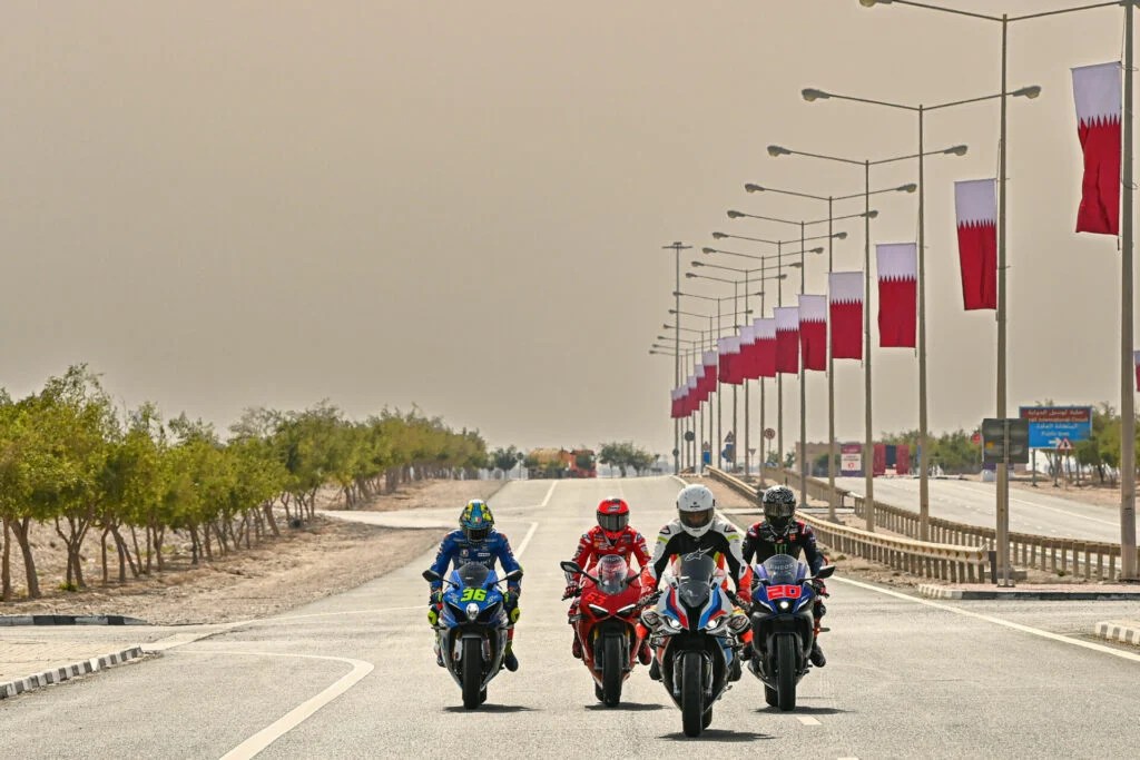 Cafu, riding a BMW M1000RR, leads Fabio Quartararo (20), Francesco Bagnaia (63), and Joan Mir (36) on a ride to Lusail Iconic Stadium.  Photo courtesy Dorna.