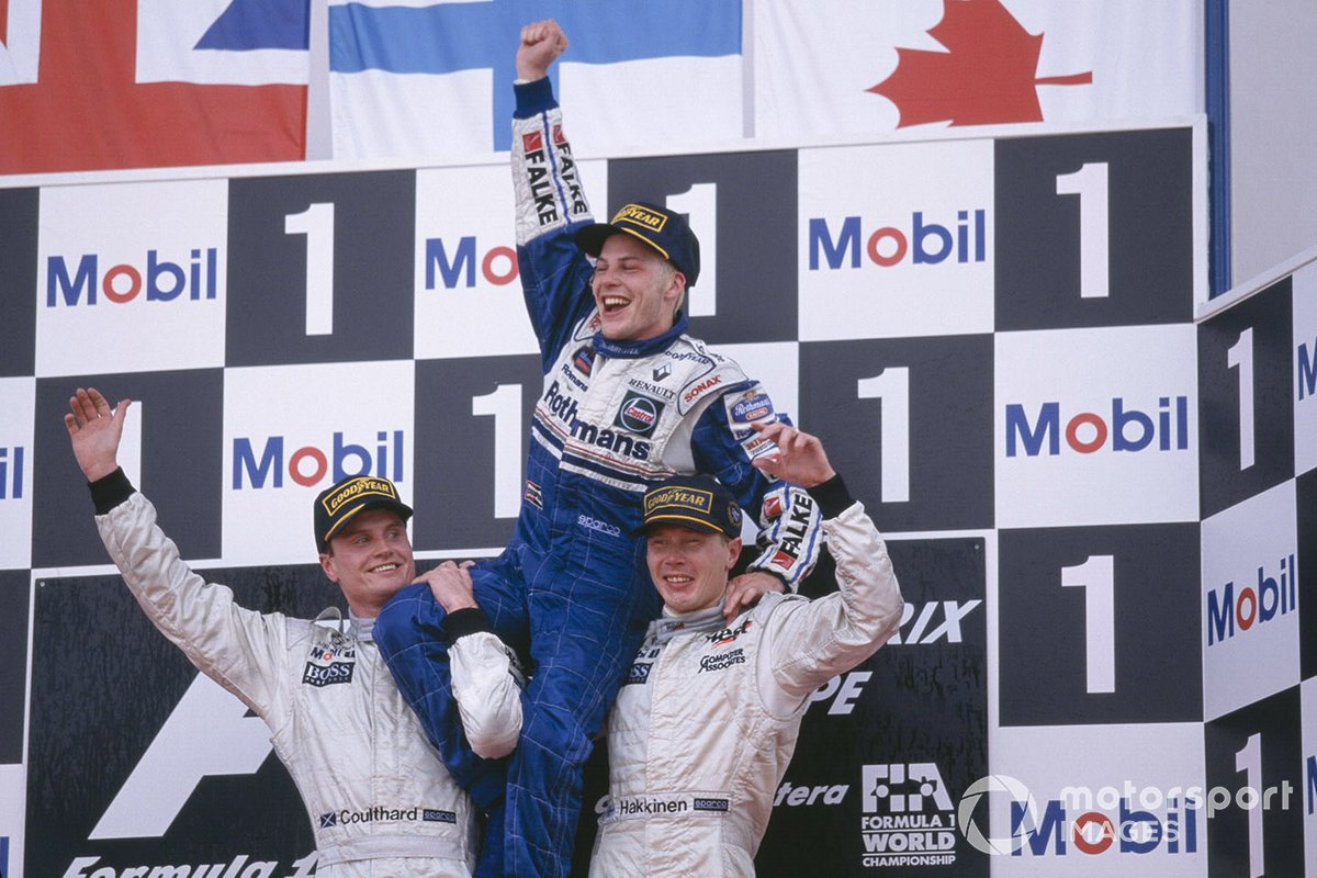 Jacques Villeneuve, Williams, celebrates becoming World Champion with McLaren Mercedes drivers David Coulthard and Mika Hakkinen