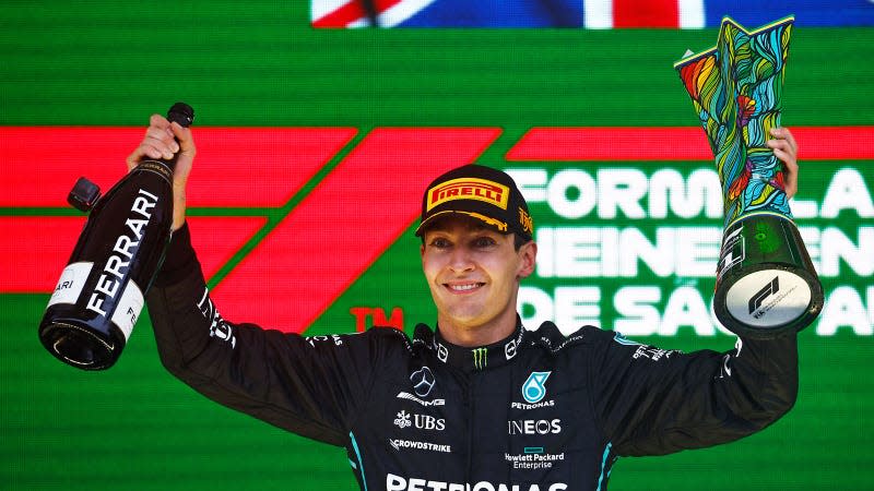 A photo of George Russell holding the winners trophy in Brazil. 