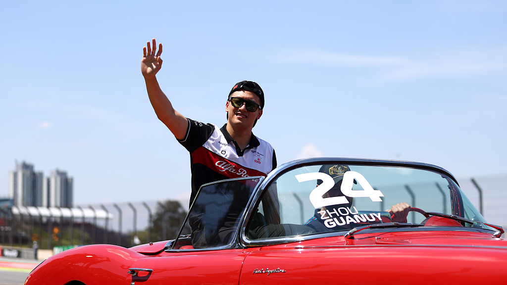   Alfa Romeo F1 driver Zhou Guanyu of China waves to the crowd during the drivers' parade before the F1 Grand Prix of Brazil in Sao Paulo, Brazil, November 13, 2022. /CFP