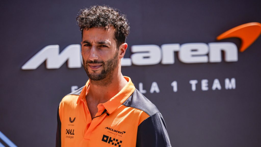 Daniel Ricciardo standing with McLaren signage behind him. Spain May 2022